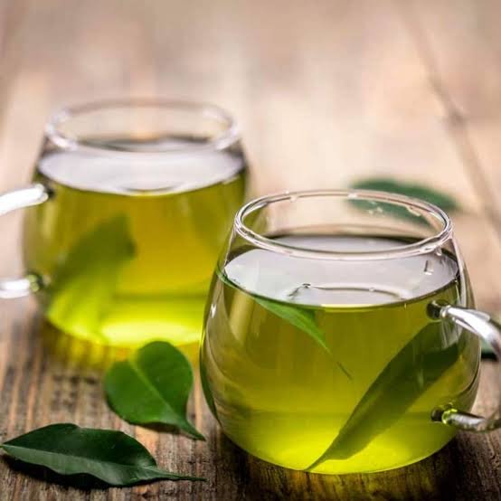Pale green Kangra green tea in a handleless ceramic cup